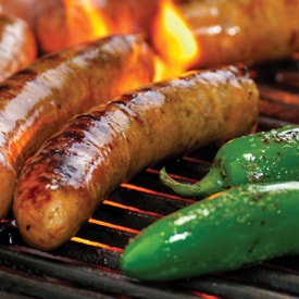 Hofmann Jalapeño Cheddar Sausage on flaming grill