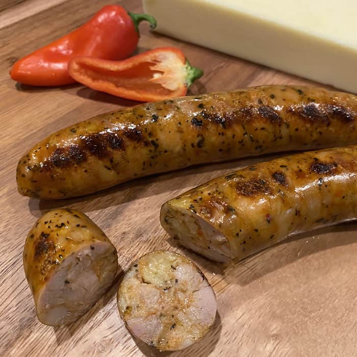 Grilled Hofmann Red Pepper Asiago Chicken Sausage on cutting board