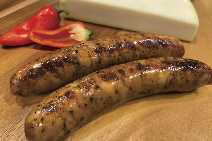Grilled Hofmann Red Pepper Asiago Chicken Sausage on cutting board