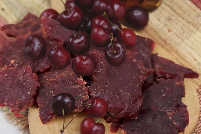 Hofmann Beef Jerky Cherry Maple on table with cherries
